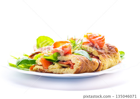 Omelet with red fish and fresh herbs on a white plate 135046071