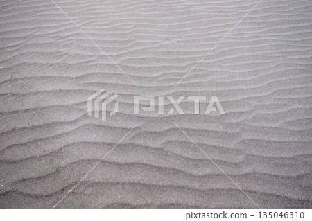 A sandy beach with fine sand undulations caused by the wind 135046310