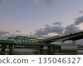 黃昏時分，火車和公路車輛駛過鐵路橋。 135046327