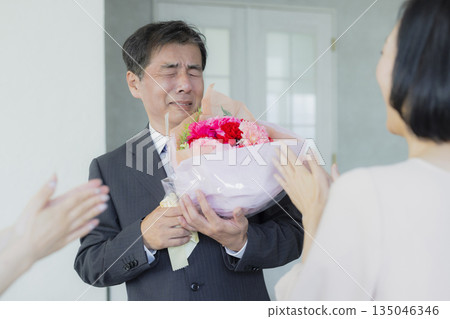 A woman giving a bouquet to a man A woman giving a bouquet to a man 135046346