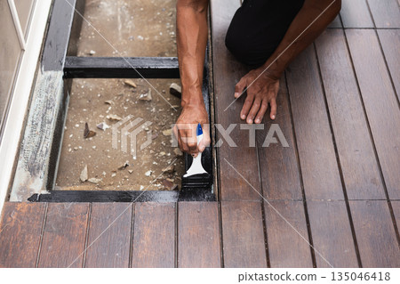 A professional painter is applying anti rust paint to a steel balcony outside a house. A professional painter is applying anti rust paint to a steel balcony outside a house. 135046418