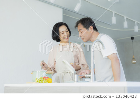 Middle-aged woman doing housework in the kitchen 135046428