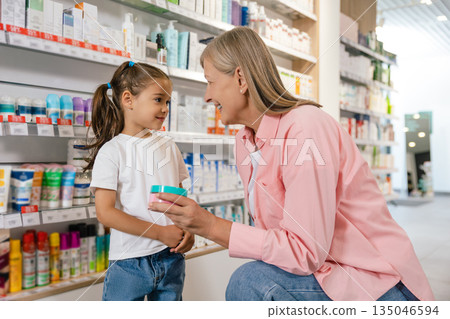 Mature woman with a little cute girl at the drug store Mature woman with a little cute girl at the drug store 135046594