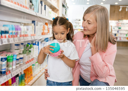 Mature woman with a little cute girl at the drug store Mature woman with a little cute girl at the drug store 135046595