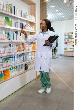 African american young woman in a lab coat at the drug store 135046770