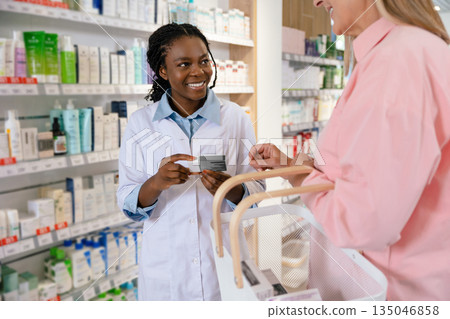 Young pharmacist advising a female customer on medicines and skin care products 135046858