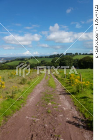 dirt road by field against sky 135047122
