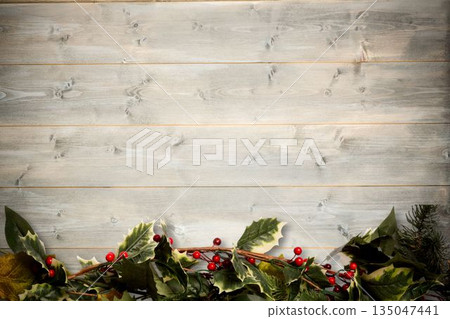 Holly twigs over wooden planks Holly twigs over wooden planks 135047441