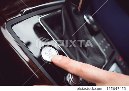 Man pressing start button in car 135047453