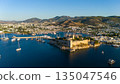 Aerial view of Bodrum Castle surrounded by marina, yachts and coastal city landscape in Bodrum, Turkey. Historic fortress on peninsula with blue sea, boats and urban shoreline at sunset. 135047546