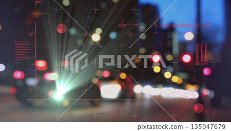 Flaring vehicle headlights lighting street at night, with bokeh taillights and red hex grid overlay 135047679