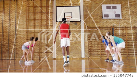 Shooting teenage boy in sportswear aiming free throw at hoop in school gym, with chalk markings Shooting teenage boy in sportswear aiming free throw at hoop in school gym, with chalk markings 135047742
