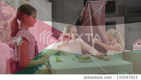 Playing tea mother and daughters at home under play tent lights, with toy tea set, cookies 135047923