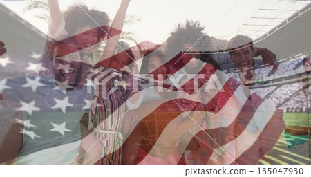 Cheering group raising arms and smiling at sports stadium, with US flag overlay and playing field 135047930