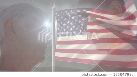 Showing mature couple facing each other outdoors, with waving American flagpole and sun lens flare 135047953