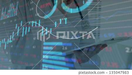 Analyzing financial charts, female doctor holding tablet in clinic with stethoscope and stylus 135047983