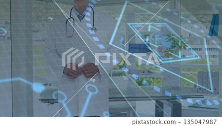 Analyzing doctor in lab coat wearing stethoscope reviewing digital building plan in medical office Analyzing doctor in lab coat wearing stethoscope reviewing digital building plan in medical office 135047987