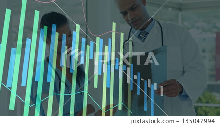 Analyzing charts, physician and nurse in uniforms holding clipboard and pen in medical corridor 135047994