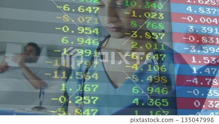 Provider with stethoscope monitoring patient in hospital, with bed phone and financial overlay 135047998