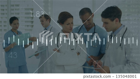 Staff in uniforms reviewing patient charts with tablet, clipboard and stethoscopes in hospital hall 135048001