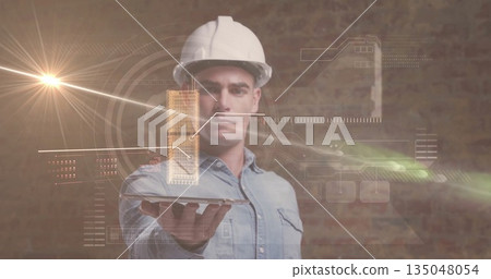 Holding tablet, denim-clad engineer wearing white helmet projecting 3D model in office, with data 135048054