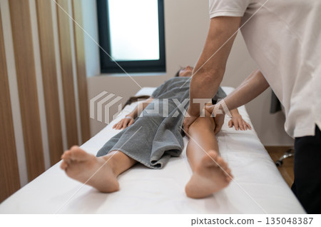 Woman lying on a couch at the manual therapist office and having massage session Woman lying on a couch at the manual therapist office and having massage session 135048387