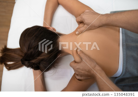 Close up of a woman lying on a couch and having back massage session 135048391
