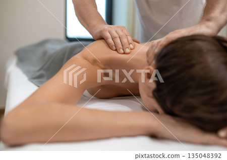 Close up of a woman lying on a couch and having back massage session 135048392