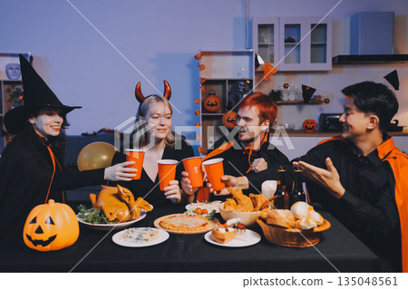 Friends enjoying a Halloween party at a bar making a toast 135048561