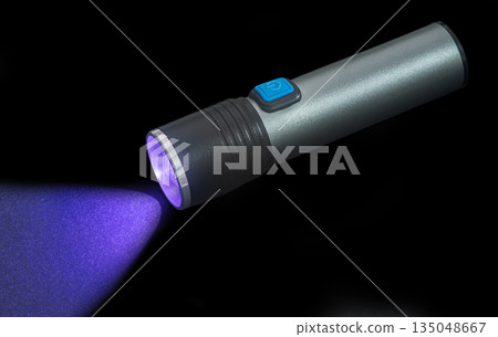 flashlight with ultraviolet light, on a black isolated flashlight with ultraviolet light, on a black isolated 135048667