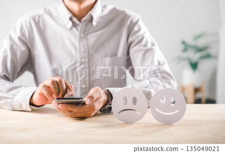 Emotional contrast, happy and sad faces represent customer feedback survey, showing mood health, person using smartphone to input opinions for services, reflecting satisfaction dissatisfaction Emotional contrast, happy and sad faces represent customer feedback survey, showing mood health, person using smartphone to input opinions for services, reflecting satisfaction dissatisfaction 135049021