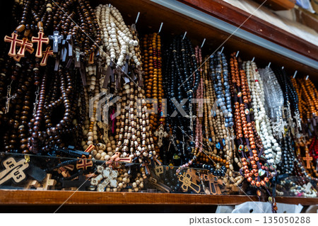 Different Christian crosses made of metal and wood hang for sale in a church store, symbolising faith, spirituality, religion, tradition, and sacred items. Religious symbol Different Christian crosses made of metal and wood hang for sale in a church store, symbolising faith, spirituality, religion, tradition, and sacred items. Religious symbol 135050288