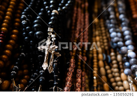 Different Christian crosses made of metal and wood hang for sale in a church store, symbolising faith, spirituality, religion, tradition, and sacred items. Religious symbol Different Christian crosses made of metal and wood hang for sale in a church store, symbolising faith, spirituality, religion, tradition, and sacred items. Religious symbol 135050291