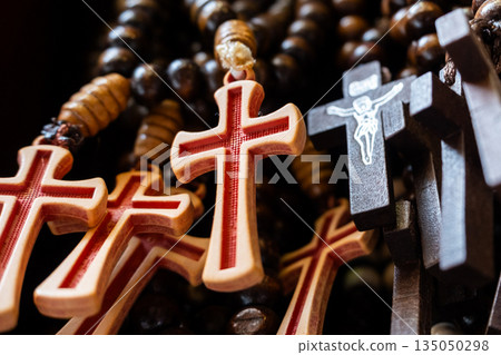 Different Christian crosses made of metal and wood hang for sale in a church store, symbolising faith, spirituality, religion, tradition, and sacred items. Religious symbol Different Christian crosses made of metal and wood hang for sale in a church store, symbolising faith, spirituality, religion, tradition, and sacred items. Religious symbol 135050298