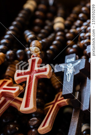 Different Christian crosses made of metal and wood hang for sale in a church store, symbolising faith, spirituality, religion, tradition, and sacred items. Religious symbol 135050299
