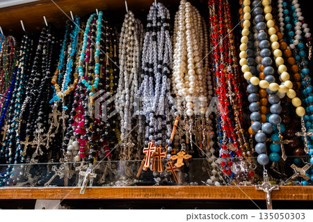 Different Christian crosses made of metal and wood hang for sale in a church store, symbolising faith, spirituality, religion, tradition, and sacred items. Religious symbol Different Christian crosses made of metal and wood hang for sale in a church store, symbolising faith, spirituality, religion, tradition, and sacred items. Religious symbol 135050303