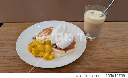 Foamed egg cold coffee with fluffy pancakes with whipped cream and mango Foamed egg cold coffee with fluffy pancakes with whipped cream and mango 135050769
