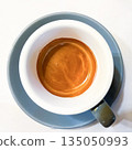 Top view of a cup of fresh espresso with rich crema on white background, minimalist flat lay coffee composition, morning caffeine and cafe concept 135050993