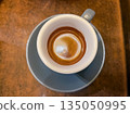 cup of espresso on brown table surface 135050995