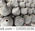 Large group of unglazed ceramic vase objects displayed in orderly pattern showing artistic texture and traditional craft design creating satisfying feeling of repetition and handmade beauty 135051636