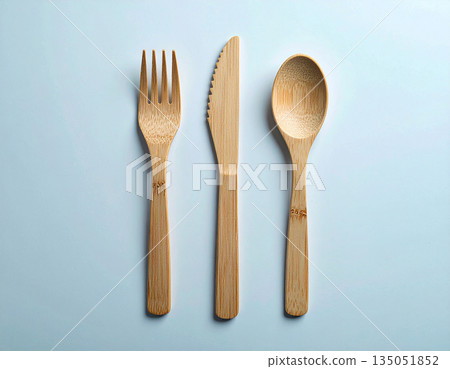 Eco friendly. Top view. Set of eco-friendly bamboo cutlery: wooden spoon, fork and knife on a white background. Eco friendly. Top view. Set of eco-friendly bamboo cutlery: wooden spoon, fork and knife on a white background. 135051852