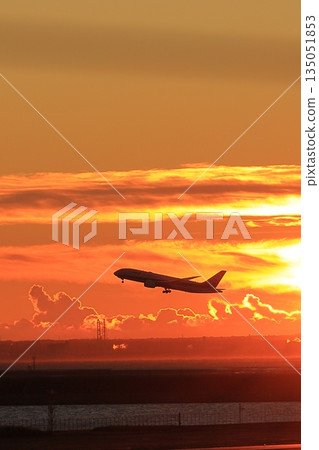 A plane taking off illuminated by the morning sun A plane taking off illuminated by the morning sun 135051853