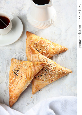 Triangular shaped dough pies. A closed meat pie. Freshly baked homemade samsa with meat filling. White background. 135051969
