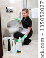 Cleaning and disinfection of toilets. A maid in a uniform cleans the toilet in the bathroom. Cleaning services in the house. Prevention of infections. The concept of cleanliness and order. 135052027