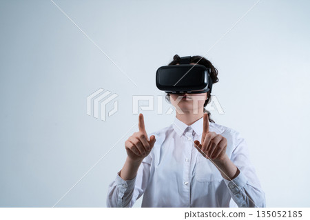 Female VR designer creating user interface elements with precise finger gestures in virtual reality design workspace Female VR designer creating user interface elements with precise finger gestures in virtual reality design workspace 135052185