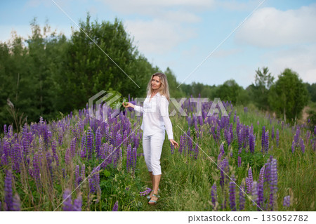 Woman enjoying a sunny day in a purple flower field 135052782