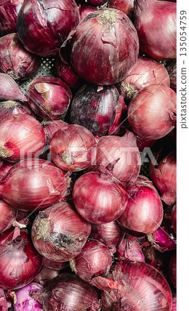 Top view of fresh organic red onions pile. Natural texture of purple vegetable skins for food background Top view of fresh organic red onions pile. Natural texture of purple vegetable skins for food background 135054759