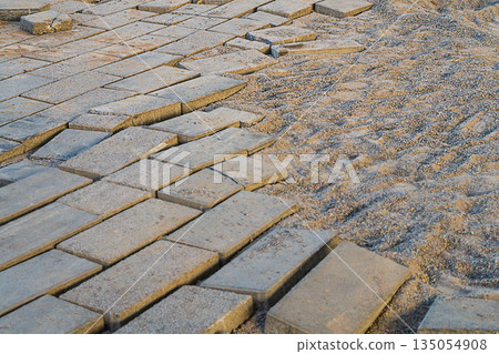 A picture of the street paving slabs, which had partially become unusable and was dismantled for the future re-laying process along with fine gravel as a cushion for the main support. 135054908