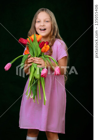 Funny little girl with a bouquet of tulips Funny little girl with a bouquet of tulips 135055406