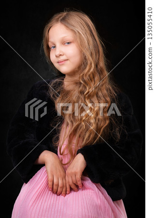 Portrait of a little girl with long white hair on a dark background. Portrait of a little girl with long white hair on a dark background. 135055410